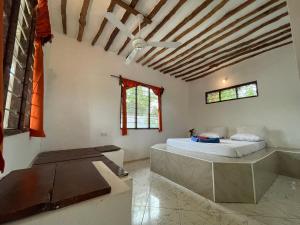 una camera da letto con un letto e un ventilatore a soffitto di Botanica Eco Lodge a Michamvi Kae
