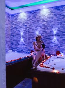 a woman sitting on the edge of a bath tub at Hotel Reloj in San Felipe de Puerto Plata