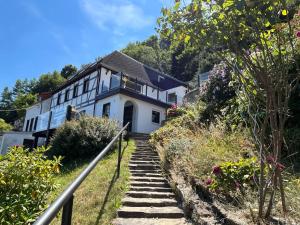 ケーニッヒスシュタイン・アン・デ・エルベにあるSaechsische-Schweiz-Ferienhaus-Wohnung-1-mit-Elbblick-Sauna-und-Kaminの階段のある丘の側の家