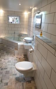 ein Badezimmer mit einem WC, einem Waschbecken und einer Badewanne in der Unterkunft Sächsische Schweiz Ferienhaus mit Elbblick Sauna und Kamin in Königstein an der Elbe