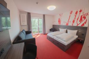 a bedroom with a bed and a couch and a chair at havenhostel Stade - Hotel in Stade