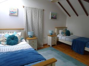 a bedroom with two beds and two night stands at Tuell Farm Cottages in Tavistock