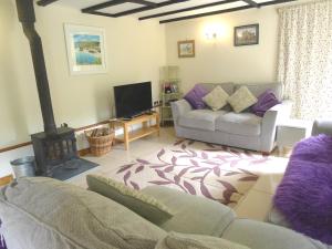 a living room with a couch and a fireplace at Tuell Farm Cottages in Tavistock