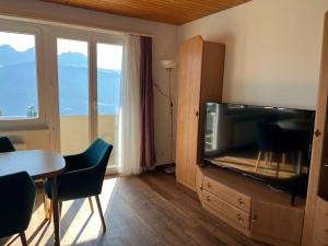 a living room with a flat screen tv and a table at Haus Panorama B, Whg Rupf in Flumserberg