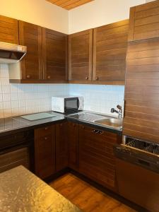 eine Küche mit Holzschränken und einem Waschbecken in der Unterkunft Haus Panorama B, Whg Rupf in Flumserberg