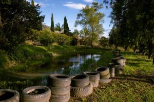 uma fila de pneus sentados ao lado de um rio em Posada la Serena em Villa de Leyva