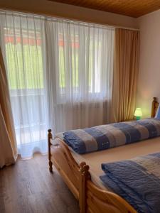 a bedroom with two beds and a large window at Haus Panorama B, Whg Rupf in Flumserberg