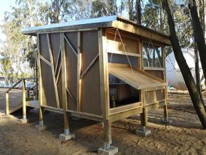 una pequeña casa de madera sentada en un parque en Camping Playa Taray, en Islantilla