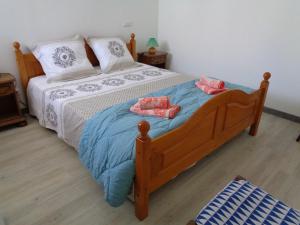 1 dormitorio con 1 cama de madera y 2 toallas en Le gite de la gare, en Challans