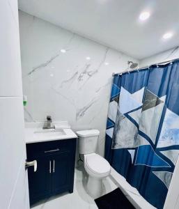 a bathroom with a toilet and a blue shower curtain at Blue Eyes in Miami