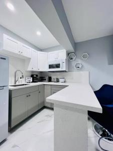 uma cozinha com armários brancos e um balcão branco em Blue Eyes em Miami