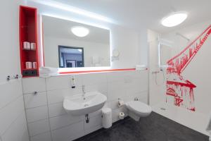 a white bathroom with a sink and a mirror at havenhostel Stade - Hotel in Stade