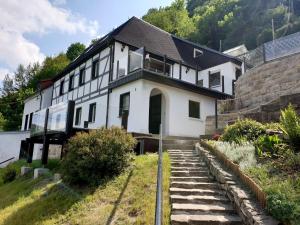 una casa blanca en una colina con una escalera en Saechsische-Schweiz-Ferienhaus-Wohnung-2-mit-hervorragendem-Panoramablick-ueber-das-Elbtal en Königstein an der Elbe