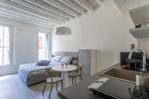 ein Schlafzimmer mit einem Bett und einem Tisch in einem Zimmer in der Unterkunft Residenza SubitoSanto - Appartamento 4B "Lucrezia" in Padua