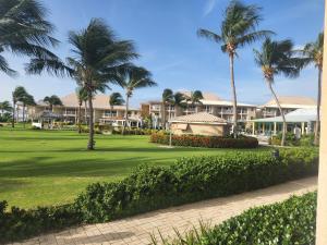 a resort with palm trees and a green yard at The Grand Caymanian Resort in George Town