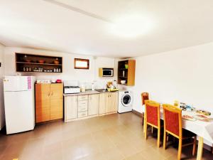 a kitchen with a white refrigerator and a table and chairs at Casa Borcean 2 in Sasca Montană