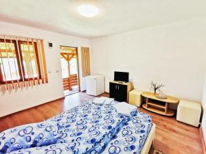 a bedroom with a blue and white bed in a room at Casa Borcean 2 in Sasca Montană