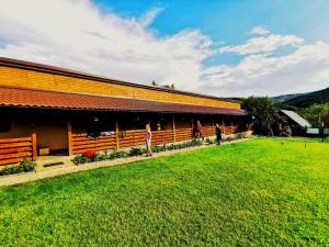 a building with a grass field in front of it at Casa Borcean 2 in Sasca Montană