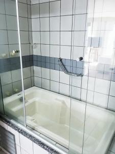 a bath tub in a tiled bathroom with a shower at PRAIA DE MUCURIPE - FRENTE MAR - Ap205 in Fortaleza