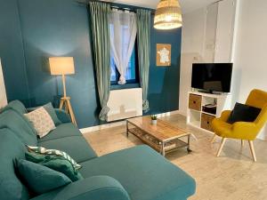 sala de estar con sofá azul y TV en Amboise - L'écrin de Léonard, en Amboise