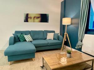sala de estar con sofá azul y mesa en Amboise - L'écrin de Léonard, en Amboise