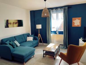 sala de estar con sofá azul y mesa en Amboise - L'écrin de Léonard, en Amboise