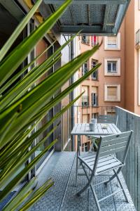 a table and chair on a balcony with a plant at L'INOX in Toulouse