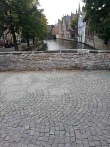 a stone walled area with a brick wall at B&B Le Foulage in Bruges