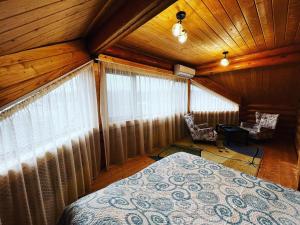 1 dormitorio con 1 cama en una habitación con techos de madera en По Щучьему Велению, en Shchūchīnsk