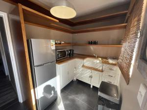 uma cozinha com armários brancos e um frigorífico de aço inoxidável em @Grace Guesthouse em Klerksdorp
