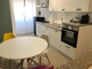 ターラントにあるCasa Kippis - Rifinito appartamento con posto autoのキッチン(白いテーブル、テーブル、椅子付)