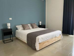 a bedroom with a large bed with two night stands at Casa Kippis - Rifinito appartamento con posto auto in Taranto