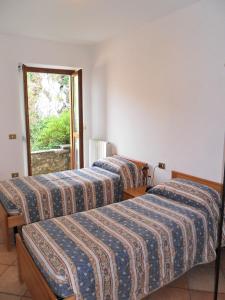 Dos camas en una habitación con ventana. en Exclusive Villa Crotto Lake View, en Varenna
