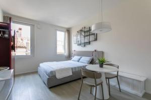 1 dormitorio con cama, mesa, mesa y sillas en Residenza SubitoSanto - Appartamento 5B "Giotto", en Padua