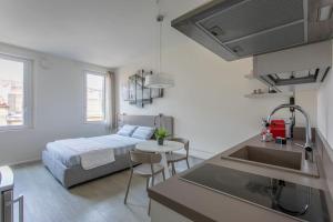 een keuken en een slaapkamer met een bed en een wastafel bij Residenza SubitoSanto - Appartamento 5B "Giotto" in Padua
