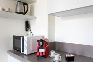 een aanrecht met een koffiezetapparaat en een magnetron bij Residenza SubitoSanto - Appartamento 5B "Giotto" in Padua