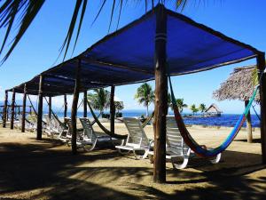a group of chairs and umbrellas on a beach at Amatique Bay Hotel in Puerto Barrios
