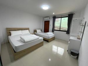 - une chambre avec 2 lits et une fenêtre dans l'établissement Khoksametchun Hostel Plus 2, à Hat Yai