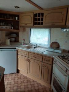a kitchen with wooden cabinets and a sink and a window at Pumpuri in Jūrmala +5 photos