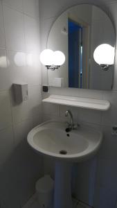 a white bathroom with a sink and a mirror at Pensjonat Kowalski in Łubowo