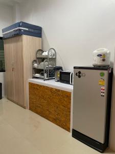 - une cuisine équipée d'un réfrigérateur à côté d'un comptoir dans l'établissement Khoksametchun Hostel Plus 2, à Hat Yai