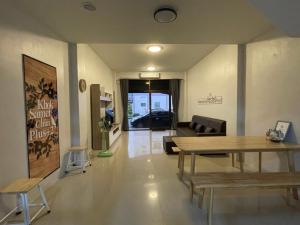 Khoksametchun Hostel Plus 2 في هات ياي: غرفة معيشة مع طاولة وأريكة