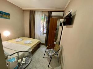 a small room with a bed and a table and chairs at Hotel Maria in Tbilisi City