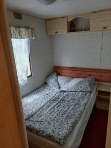 a small bedroom with a bed in a trailer at Pumpuri in Jūrmala