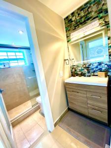 ein Bad mit einer Dusche, einem Waschbecken und einem WC in der Unterkunft Premium Modern waterfront apartment with Miami Skyline view on the bay 5 mins drive to Miami Beach with free parking in Miami Beach