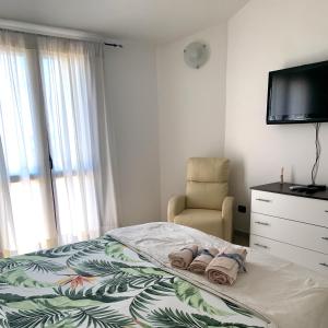a bedroom with a bed and a chair and a television at Villa Maria in Maracalagonis