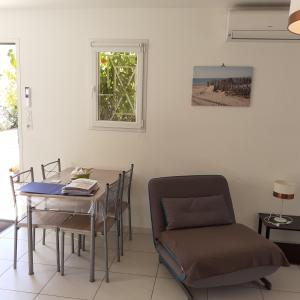 een eetkamer met een tafel en stoelen en een raam bij Maison indépendante in Salinelles