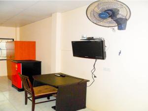 a room with a table and a fan on the wall at Bonus Bungalow in Chalong