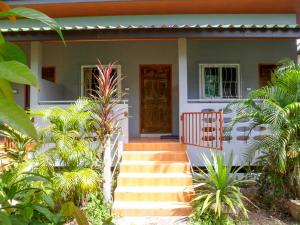 a house with stairs leading to the front door at Bonus Bungalow in Chalong