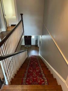 un escalier avec un tapis rouge au sol dans l'établissement The Manor at Glen Jean Meadows, 